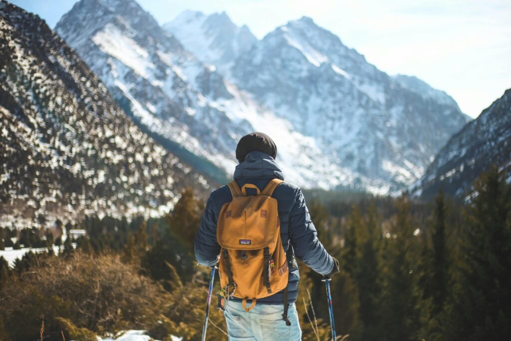 A lone hiker with a backpack explores a scenic winter mountain landscape.